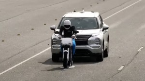 An SUV approaches a model of a motorcyclist in an Insurance Institute for Highway Safety automatic emergency braking test